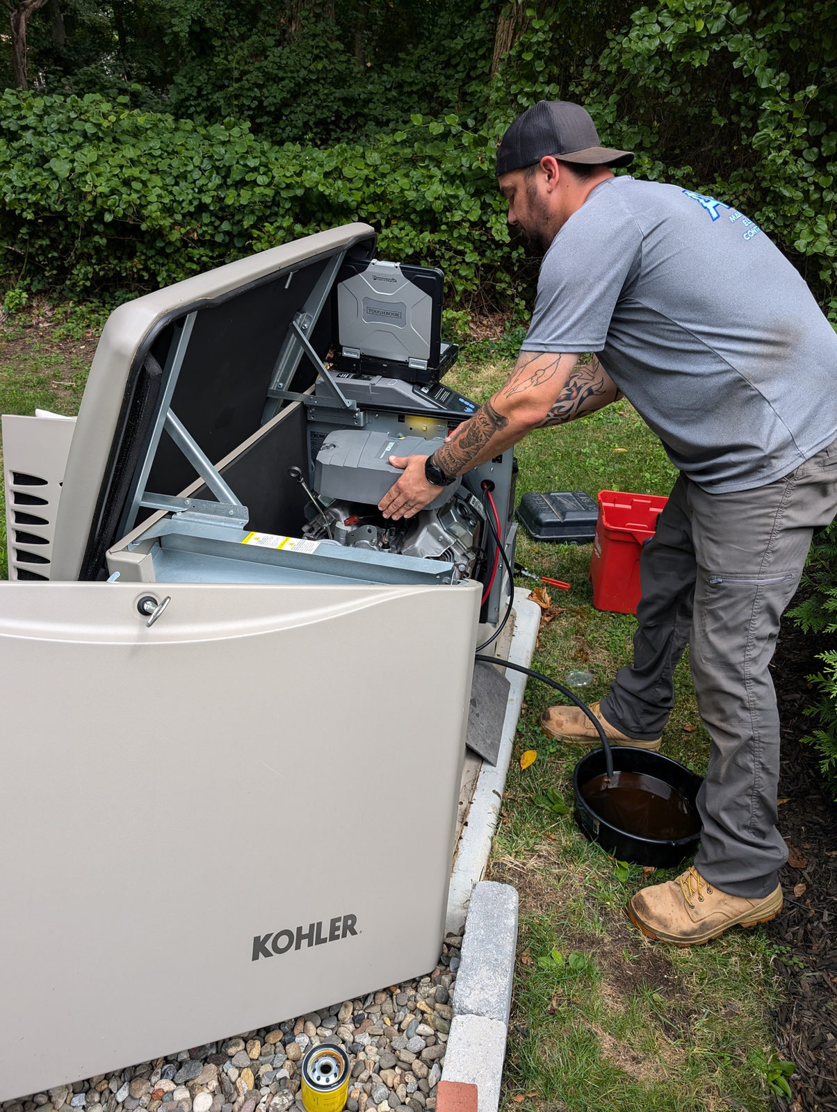 ADK technician servicing an open KOHLER standby generator