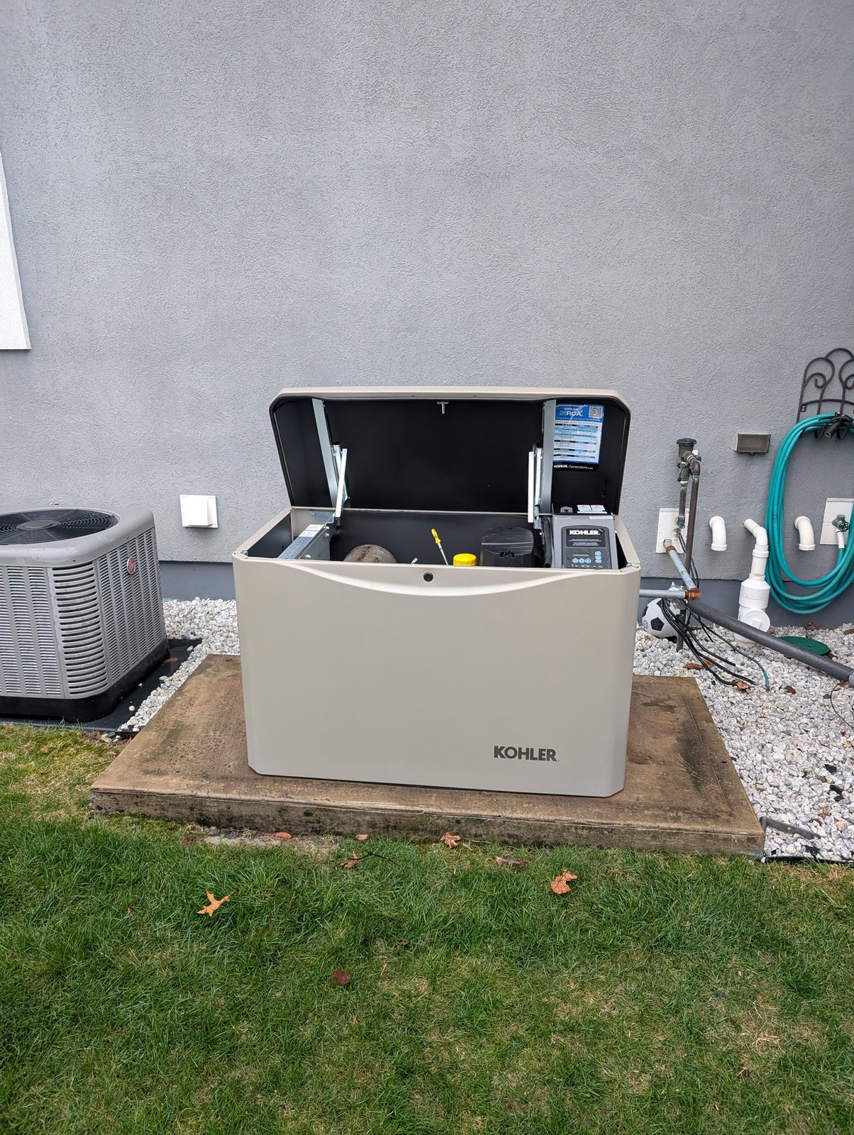 Open KOHLER standby generator installed on a concrete pad