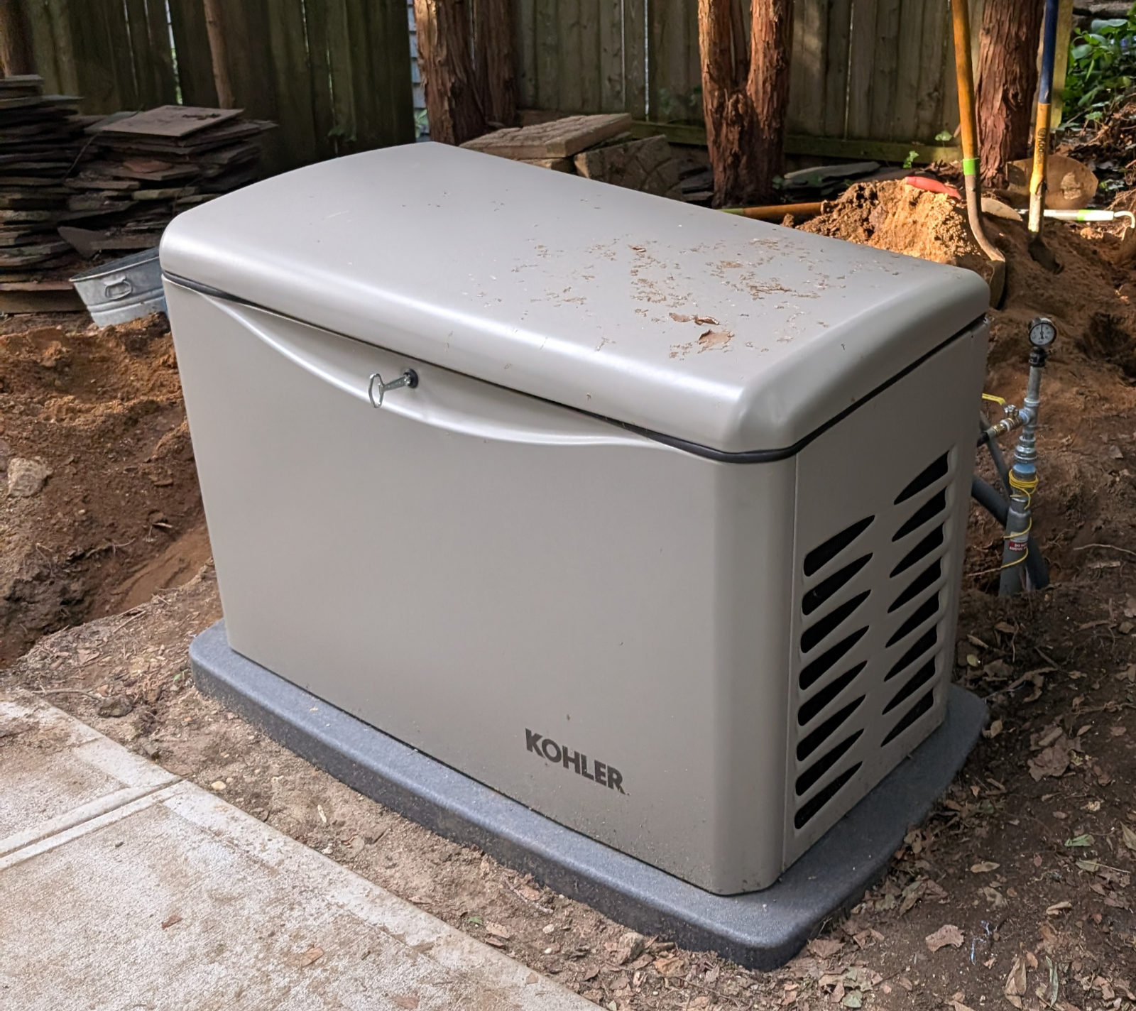 Completed KOHLER standby generator installation beside a landscaped home