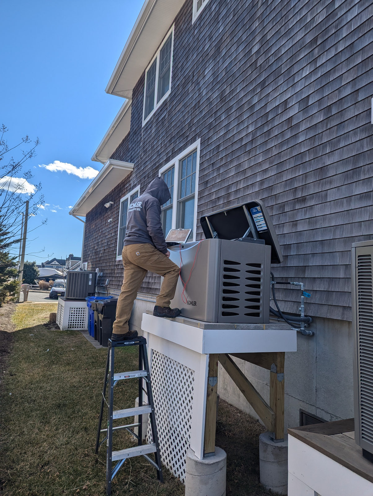 ADK technician servicing an elevated KOHLER generator