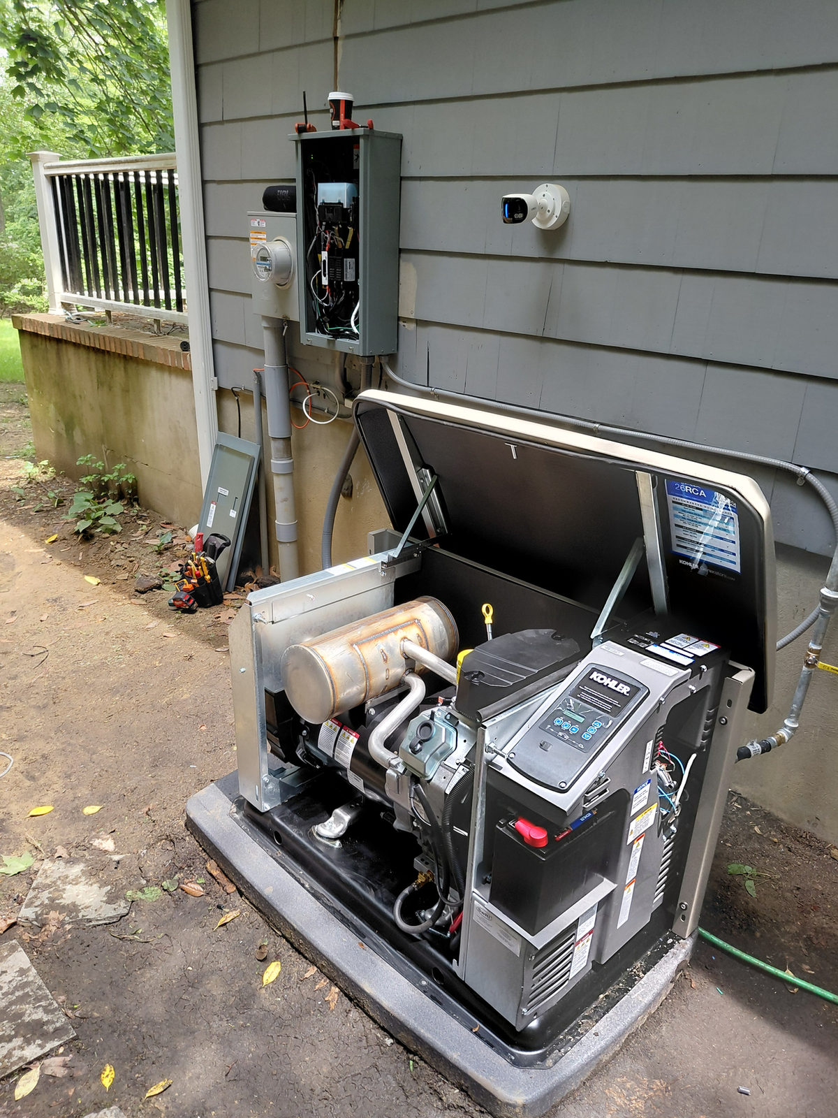 Open KOHLER standby generator connected beside a home